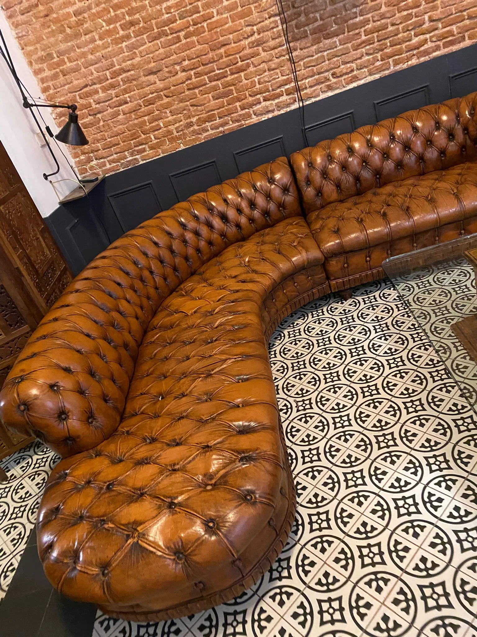 Sofá Chesterfield restaurado en cuero cognac sobre suelo hidráulico